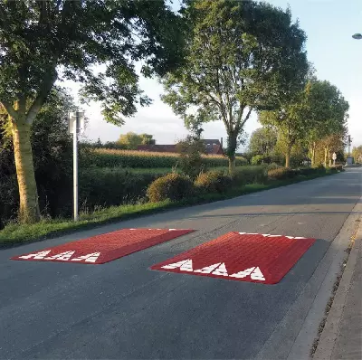 Two red and white road speed cushions for Europe on a country road