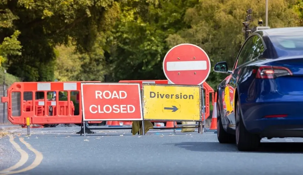 Two traffic signs are standing on the ground, one reads "Road Closed" and the other reads "Diversion".